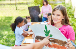 Teacher guiding children in outdoor conservation education projects.